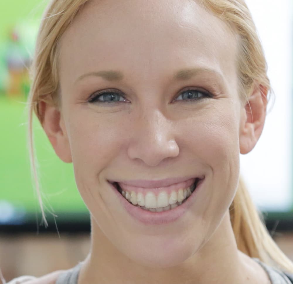 woman smiling and wearing clear aligners